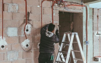 Electrician installing wiring during building renovation in Türkiye.